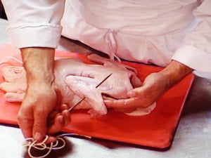 Pass the trussing needle through the wing - FG